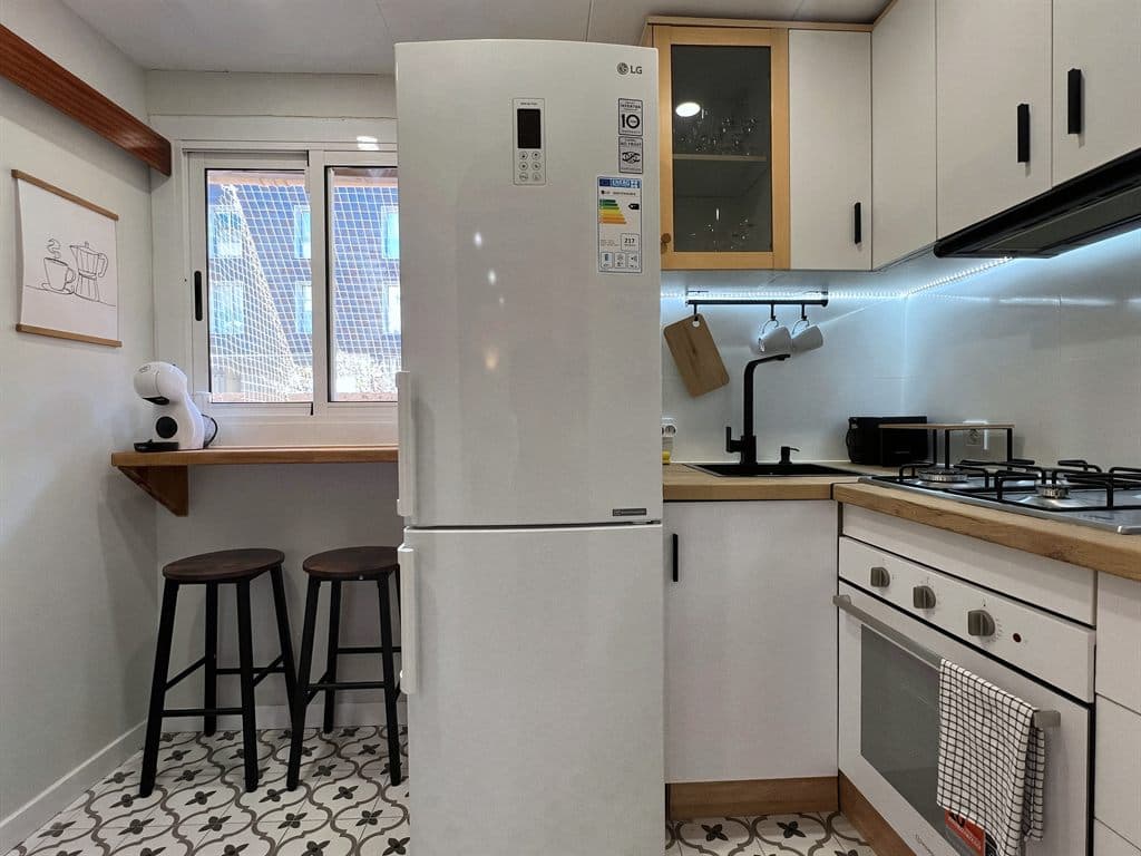 Cocina con frigorífico, horno y placa instalados en Ferrol