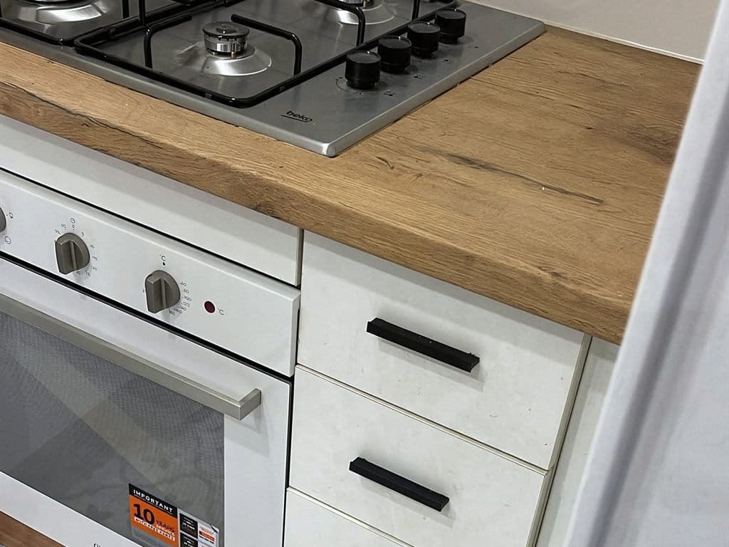Encimera de madera con placa de gas y cajones en una cocina de Ferrol