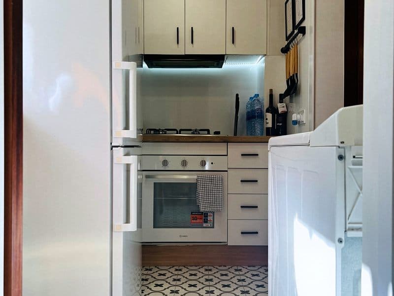 Cocina renovada por completo con frigorífico integrado y suelo hidráulico en Ferrol
