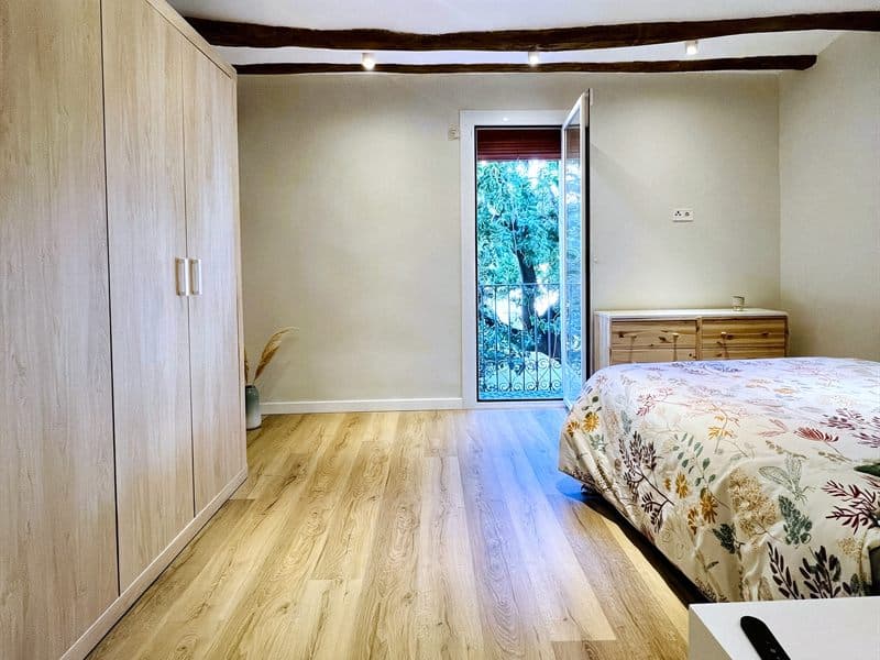 Dormitorio con armarios empotrados y suelo de madera tras una reforma en Ferrol